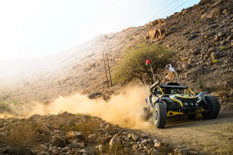 A FOXATVs buggy moving through dust on an Omani hillside