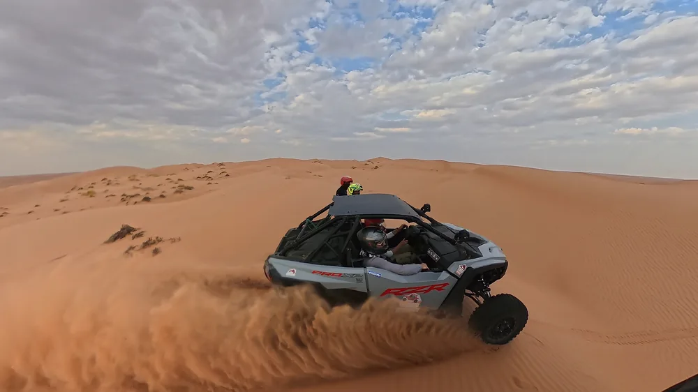 A FOX ATVs buggy driving across Oman’s golden dunes