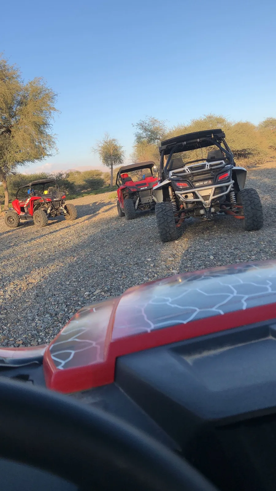 A driver’s view of an off-road convoy following a stony trail