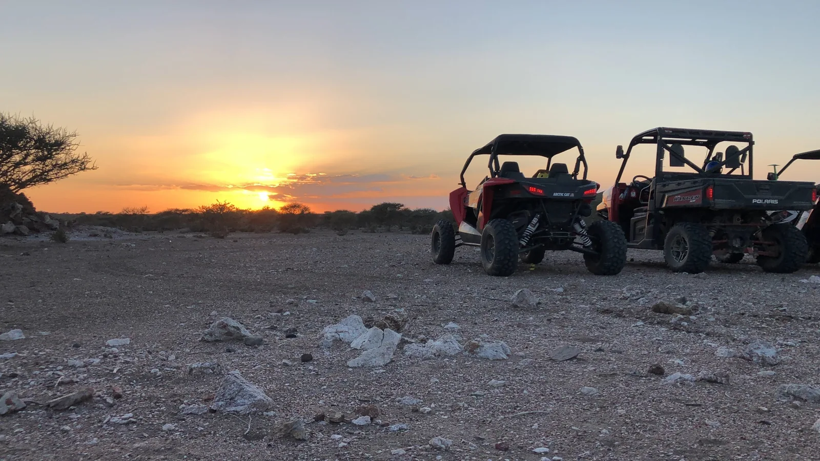 Off-road vehicles stopped together at sunset during an earlier journey