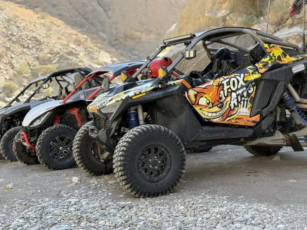 FOX ATVS off-road vehicles gathered beside a rocky trail