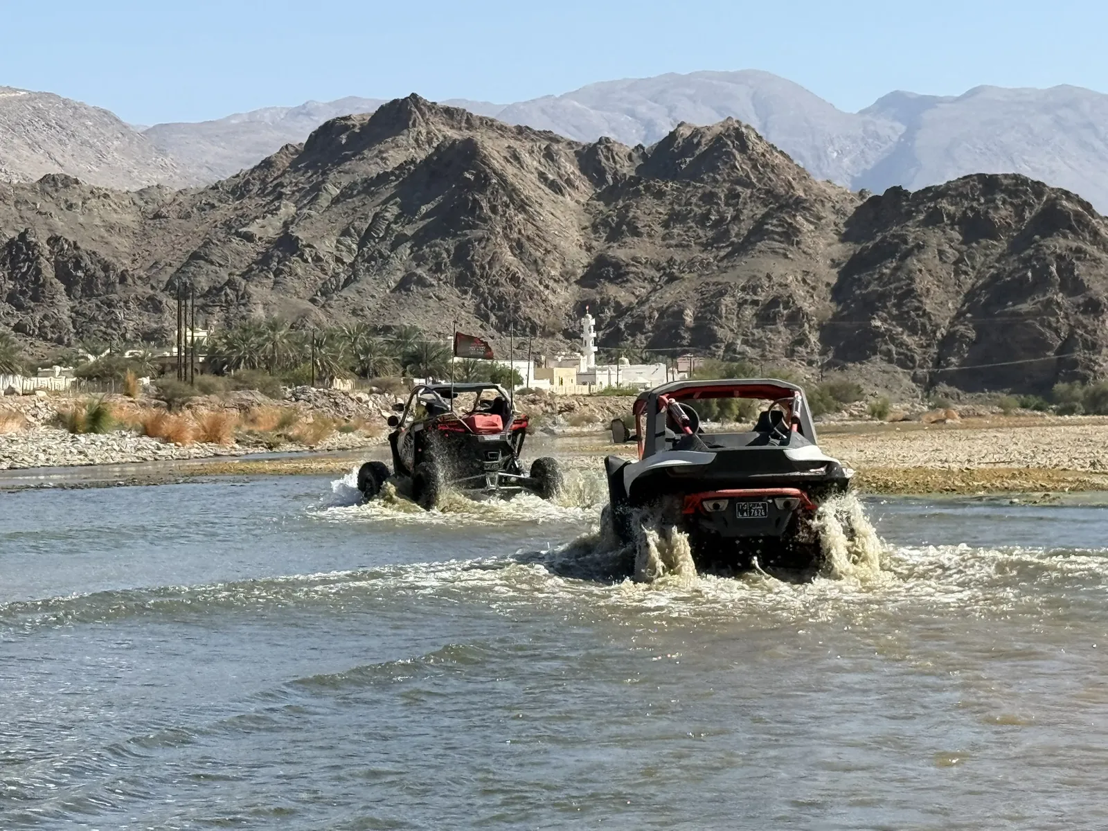 Two UTVs making a guided water crossing in Wadi Al Tayeen