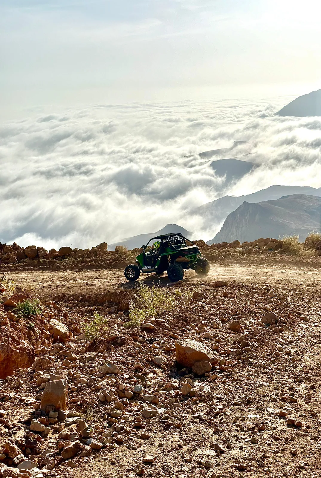 A FOX ATVS buggy on a mountain track above a layer of cloud