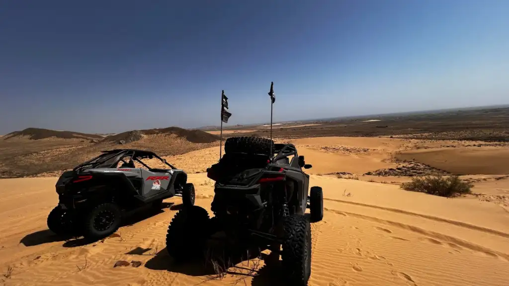 FOX ATVs buggies at a dune viewpoint above an open desert landscape