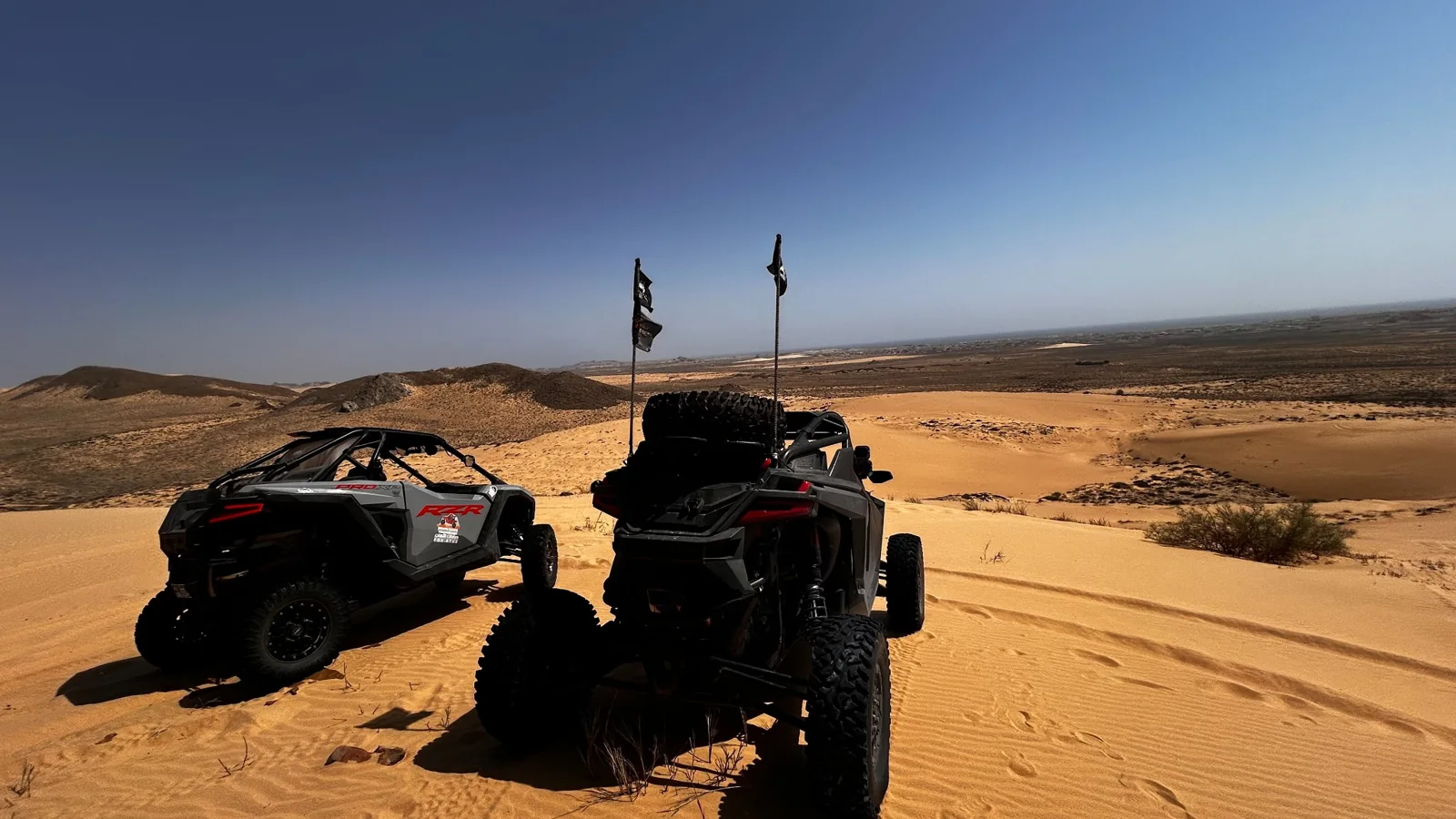 FOX ATVs buggies at a dune viewpoint above an open desert landscape