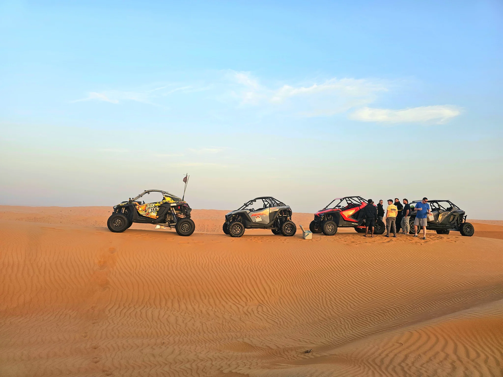 FOXATVs group beside their vehicles at a desert stop
