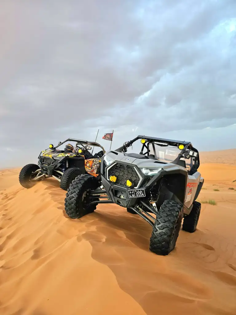 Two-seat FOXATVs buggies parked on desert sand