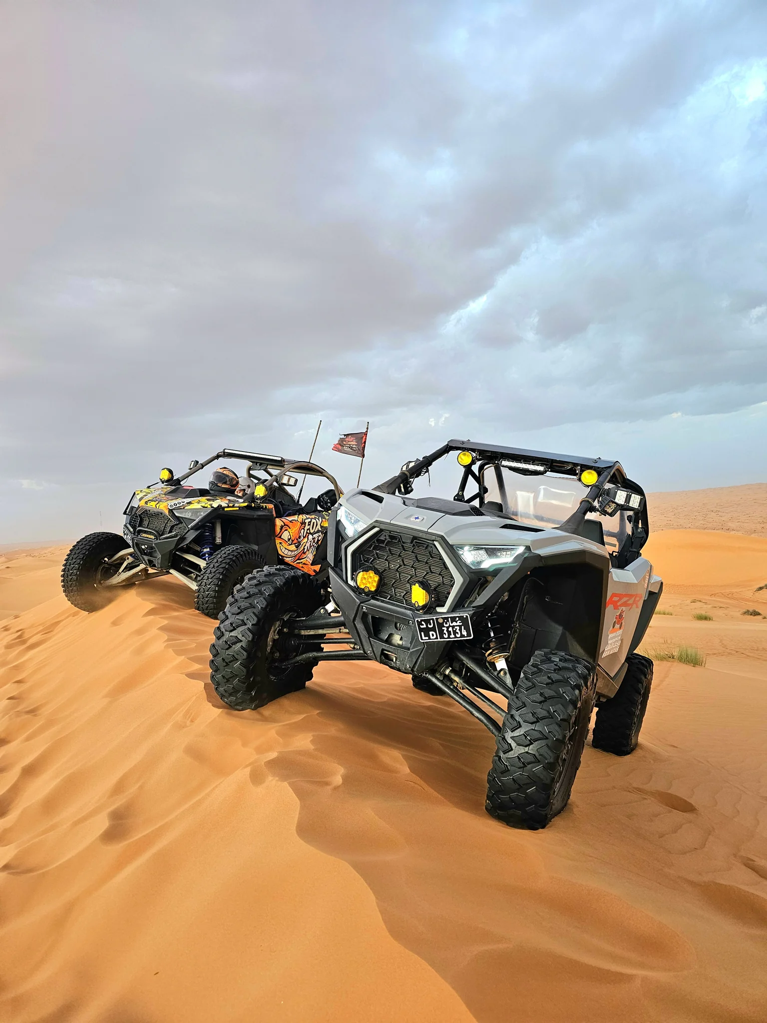 Two-seat FOXATVs buggies parked on desert sand