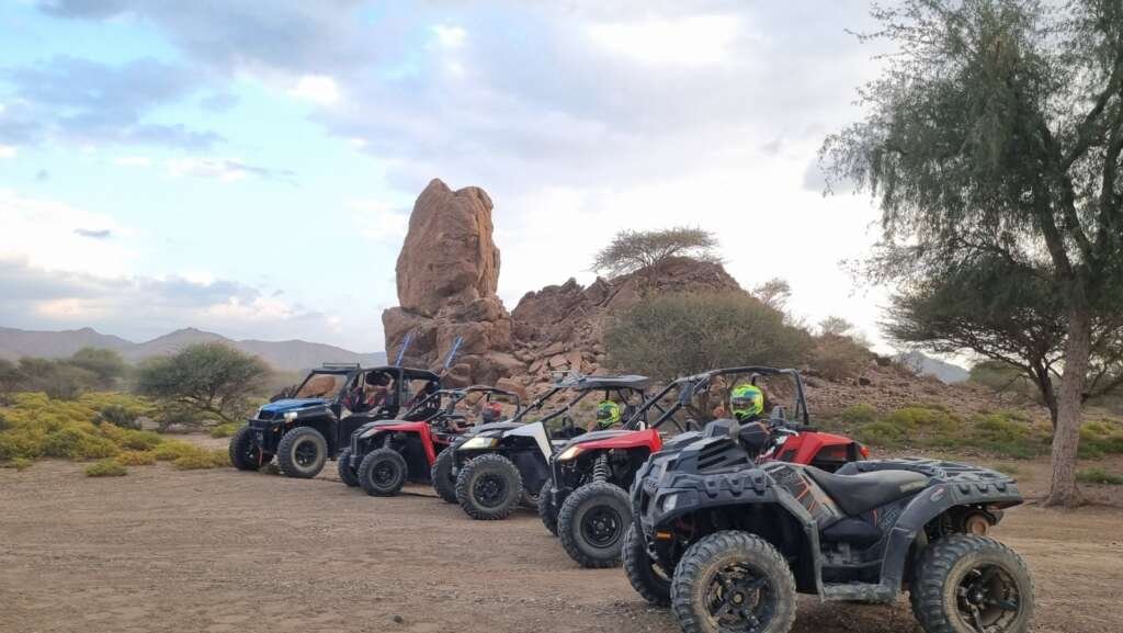 FOXATVs off-road vehicles beside the tall rock formation in Wadi Al Rak