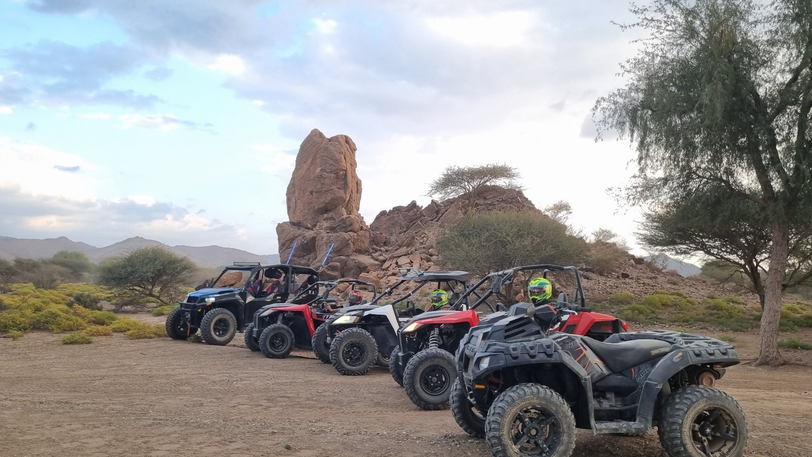 FOXATVs off-road vehicles beside the tall rock formation in Wadi Al Rak