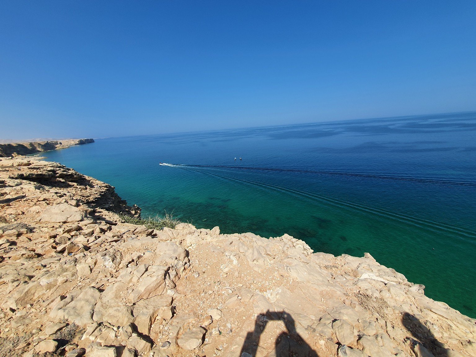 Rocky coastal highlands overlook the clear blue Arabian Sea in Oman