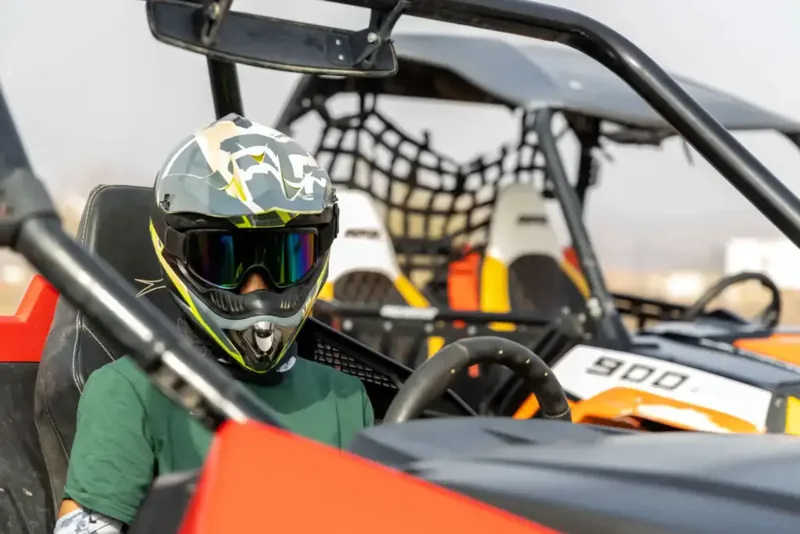 A participant wearing a helmet and goggles in a FOXATVs buggy